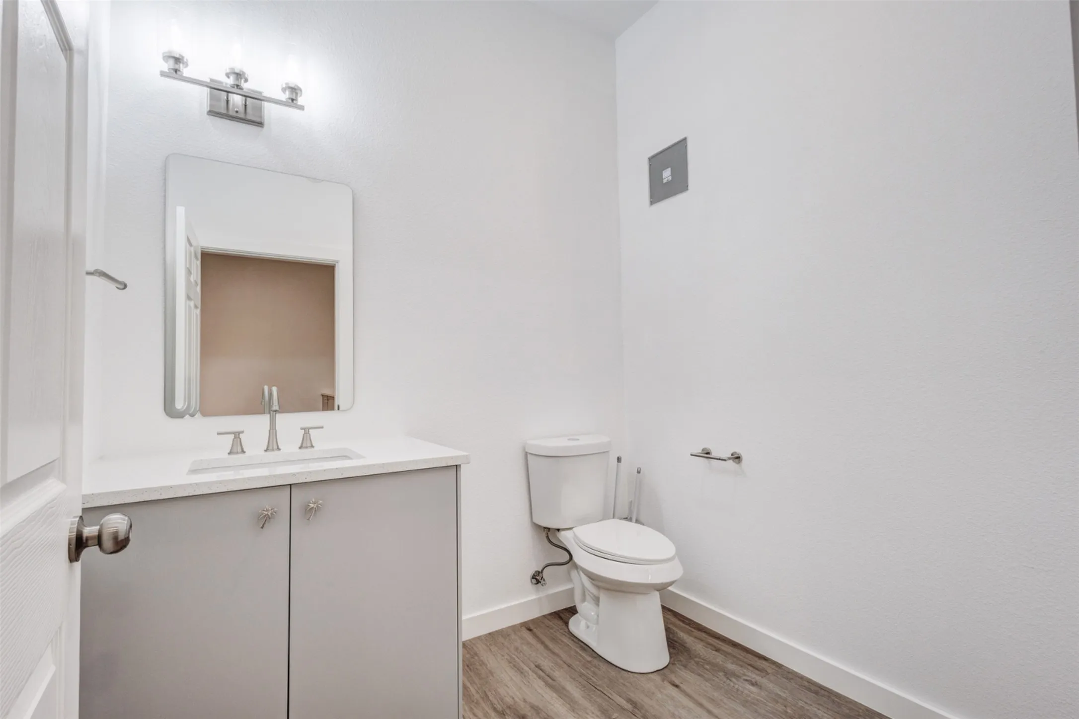 White vanity with a light gray cabinet, white countertop, and brushed nickel hardware