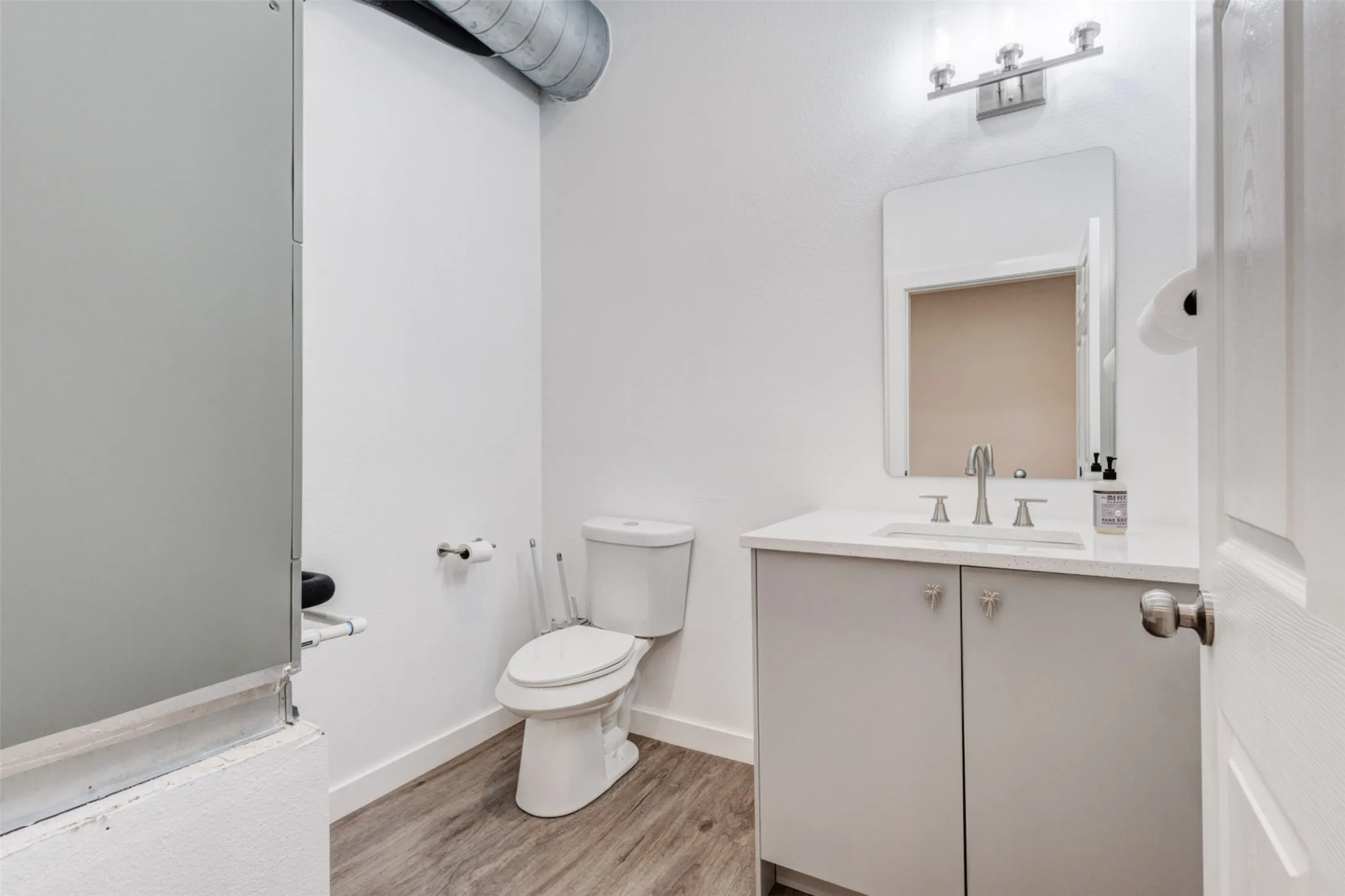 White vanity with a light countertop, undermount sink, and brushed nickel faucet