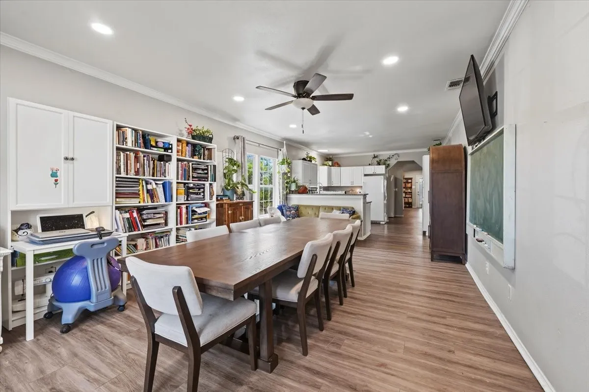 Open-concept living space with wood-finish flooring, built-in shelving, and recessed lighting