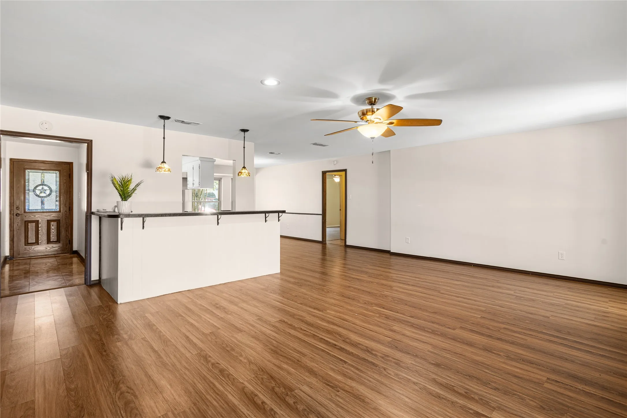 Open concept living area featuring wood-finish flooring, recessed lighting, and a ceiling fan