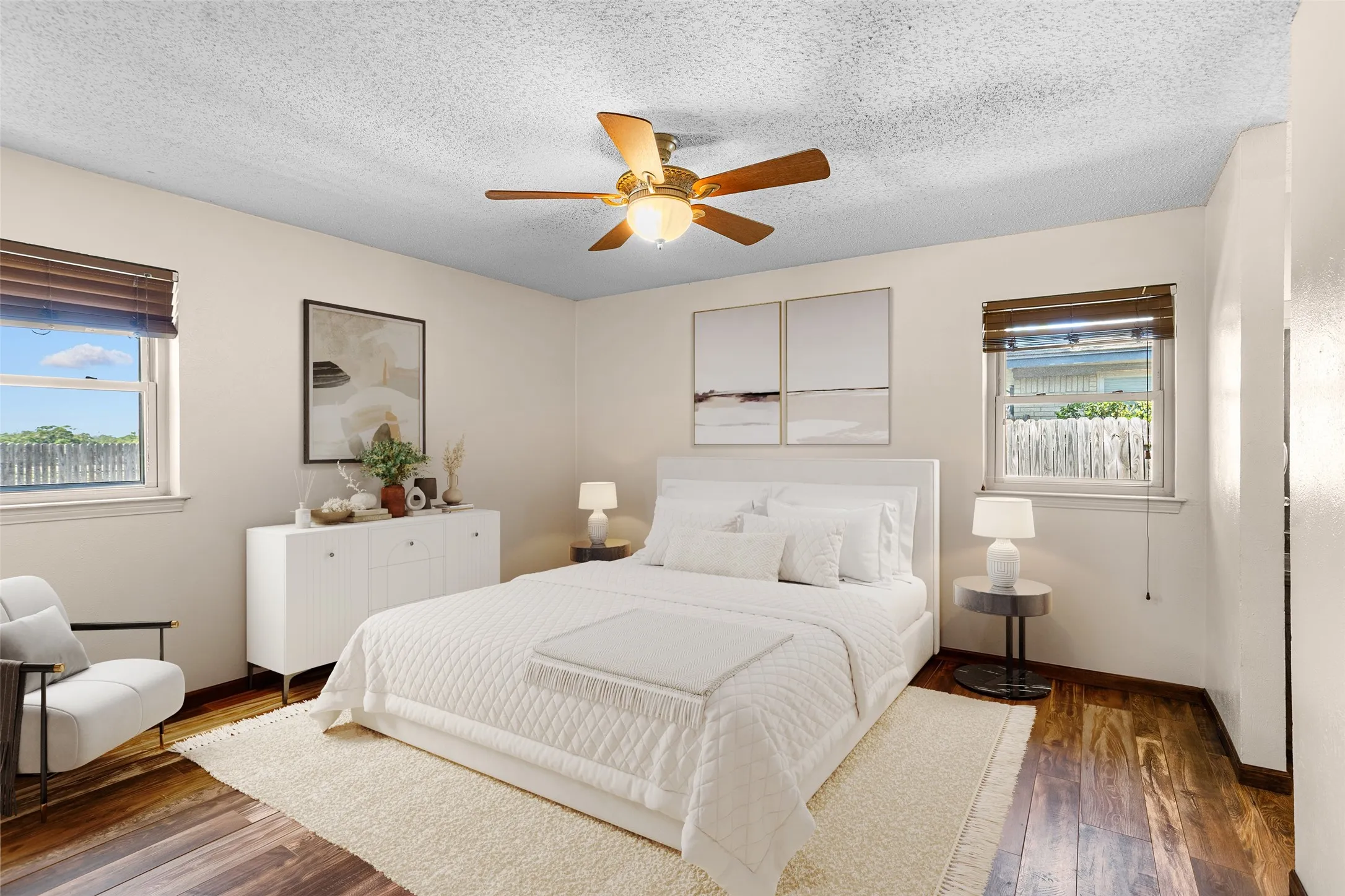 Virtually Staged Bedroom with Wood-finish flooring, ceiling fan with integrated lighting, and two windows with blinds