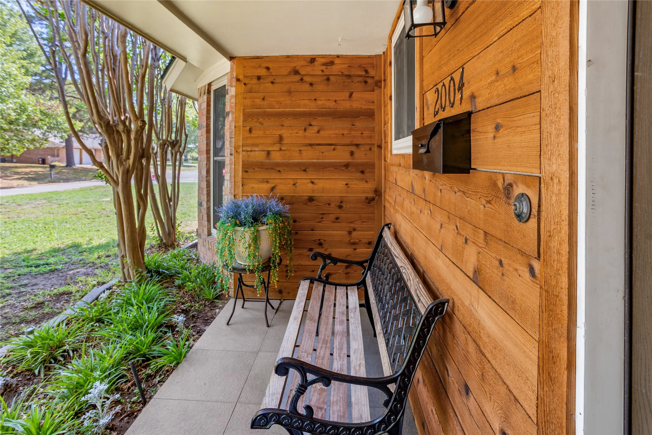 Wood-paneled exterior wall with integrated mailbox and house numbers