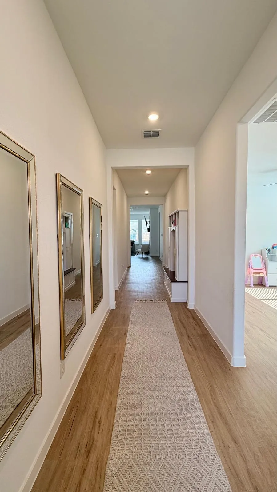 Hallway with recessed lighting, wood-finish flooring, and white baseboards
