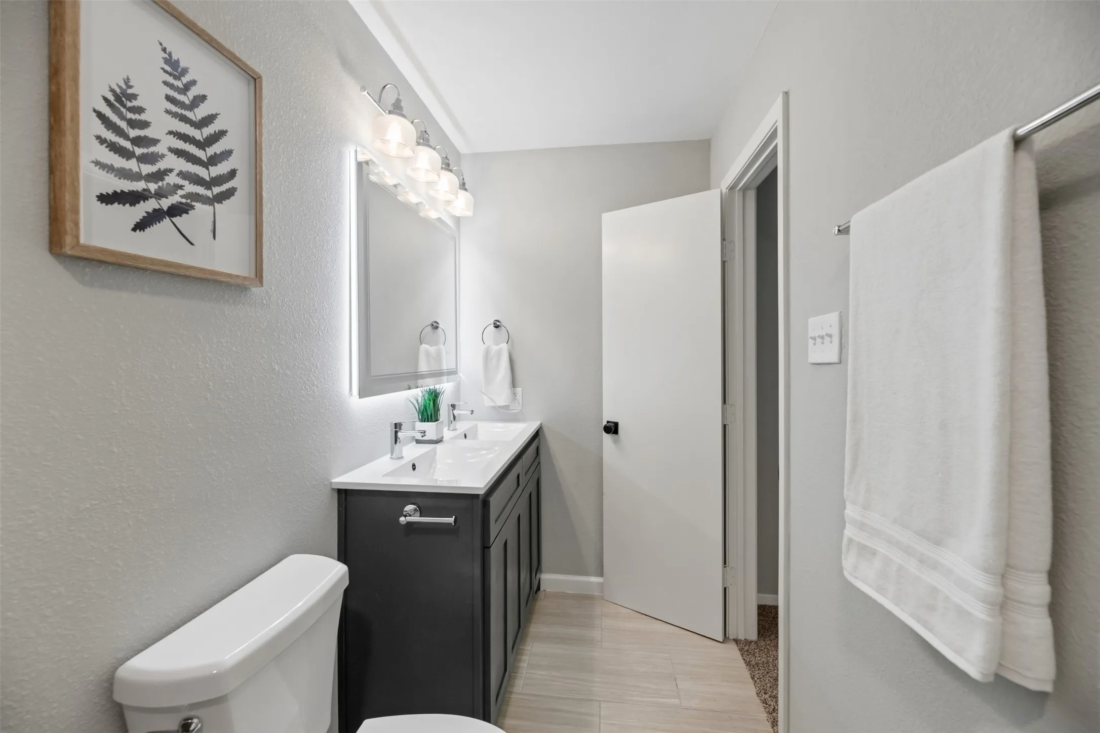 Primary vanity has dual sinks, new faucets, and a new light fixture