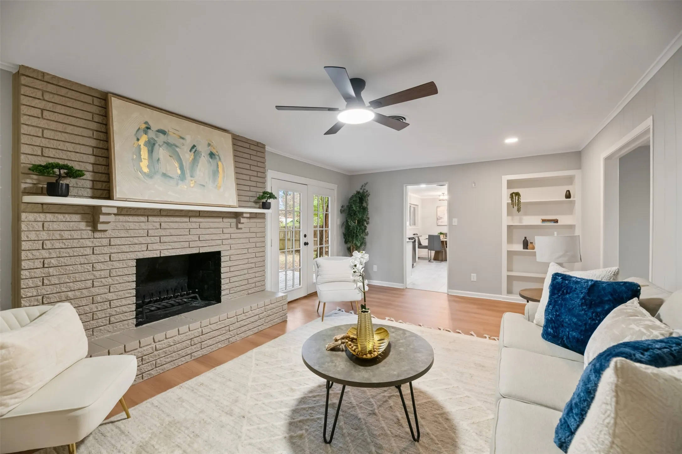 Living room with wood burning fireplace, new floors and ceiling fan