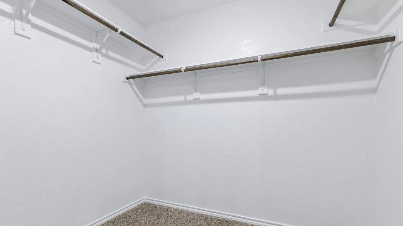 Spacious closet with multiple hanging rods, white shelving, and carpet flooring