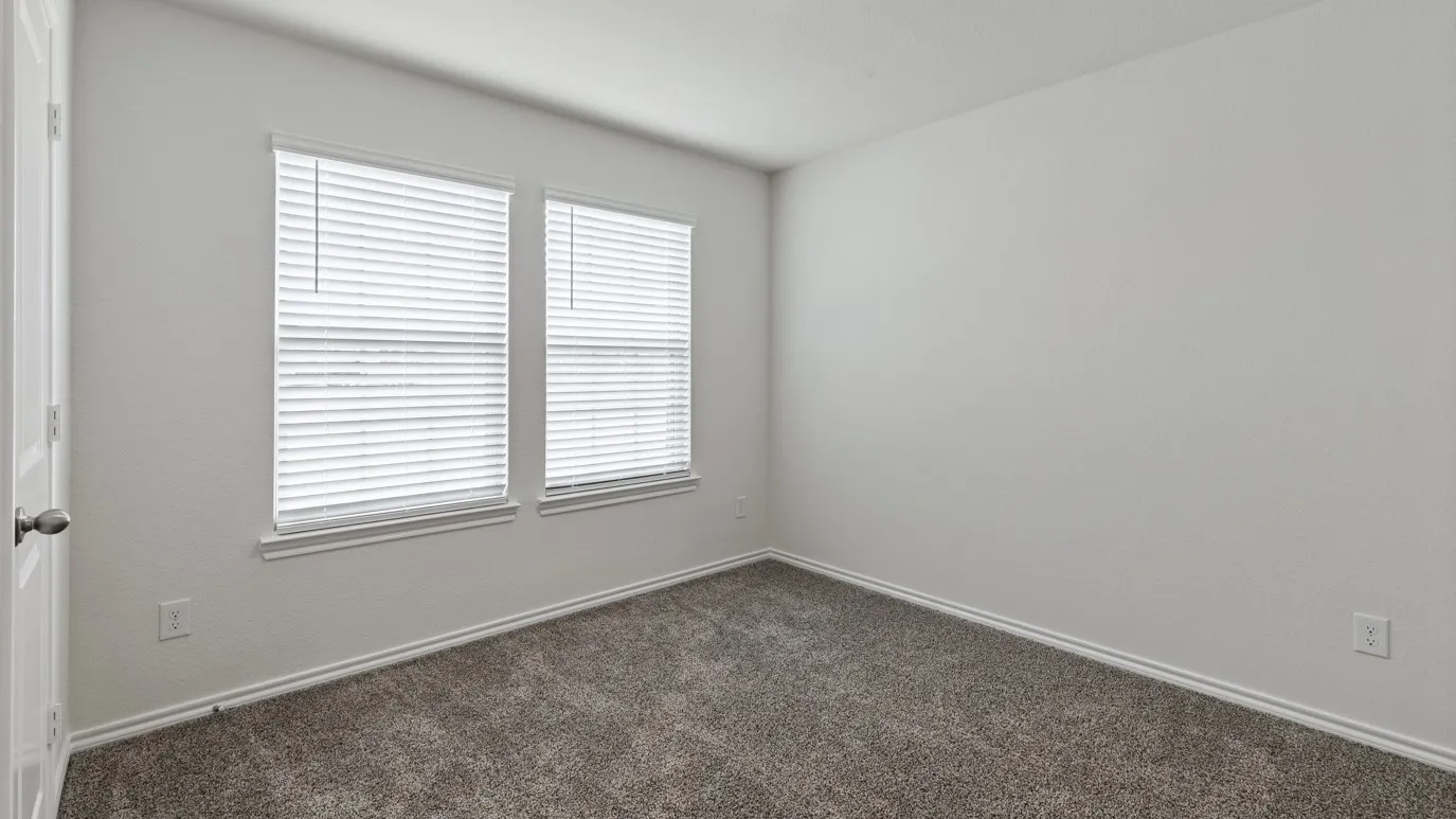 Neutral-toned wall paint, two windows with blinds, gray carpet, and white trim