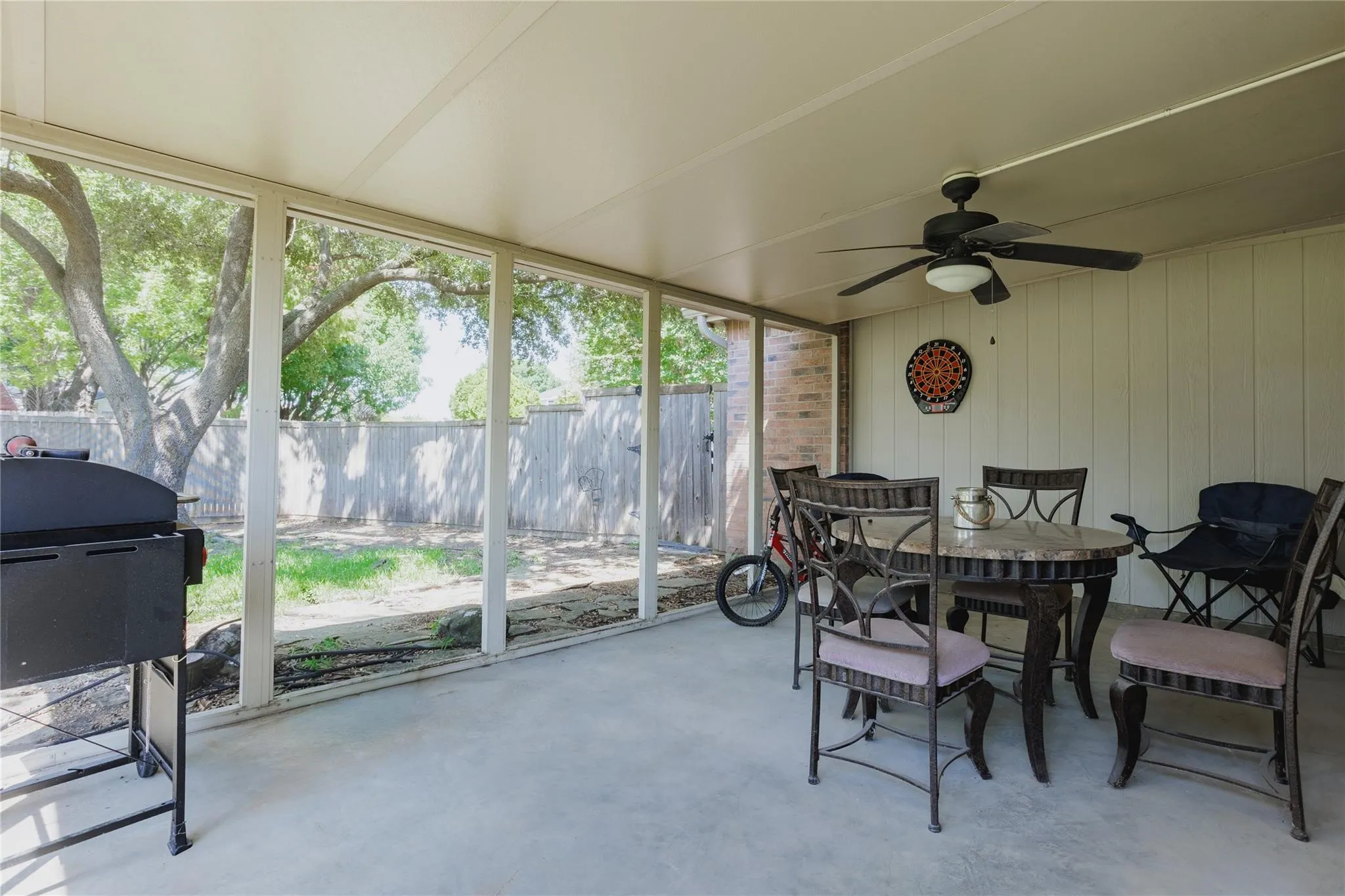 Screened patio with a mounted ceiling fan and overhead lighting