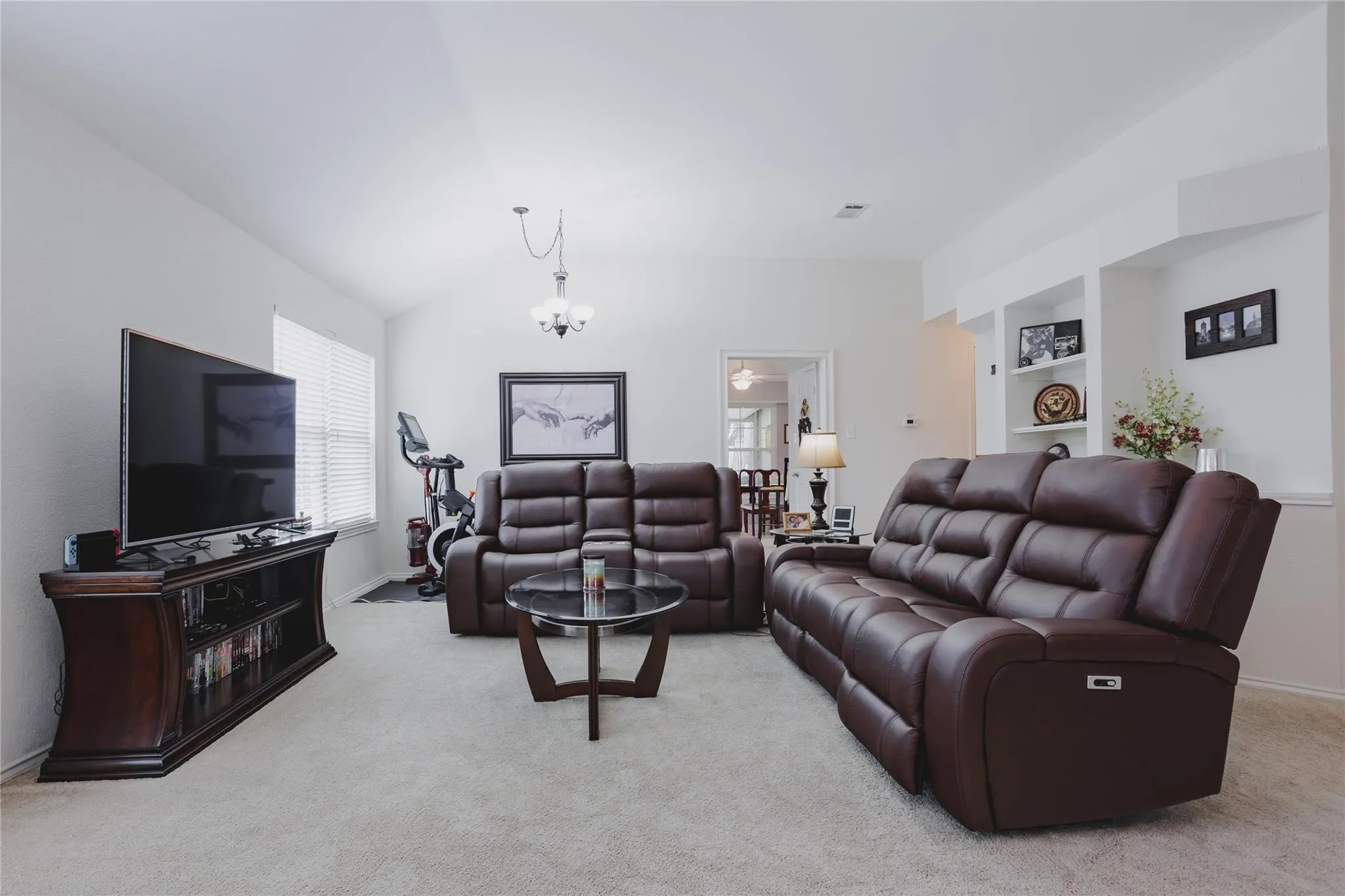 Vaulted ceiling, recessed lighting, built-in shelving, chandelier, and a window with blinds