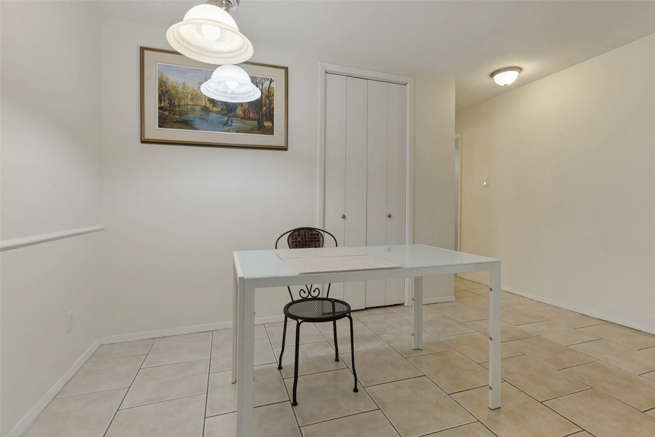 Tiled flooring, white walls, and a built-in closet with bi-fold doors