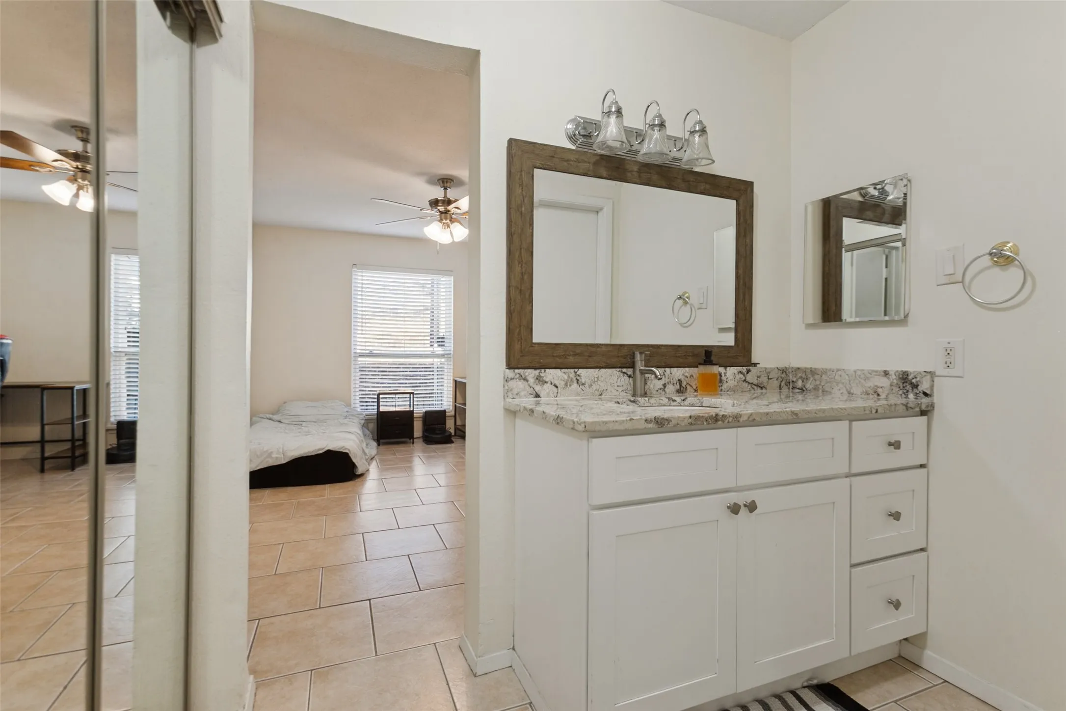 White shaker-style vanity with a stone countertop and an undermount​​‌​​​​‌​​‌‌​‌‌​​​‌‌​‌​‌​‌​​​‌​​ sink
