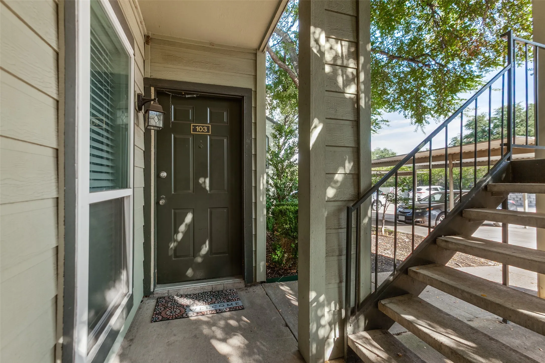 Entryway featuring a panel door, an exterior wall sconce, and a window with blinds