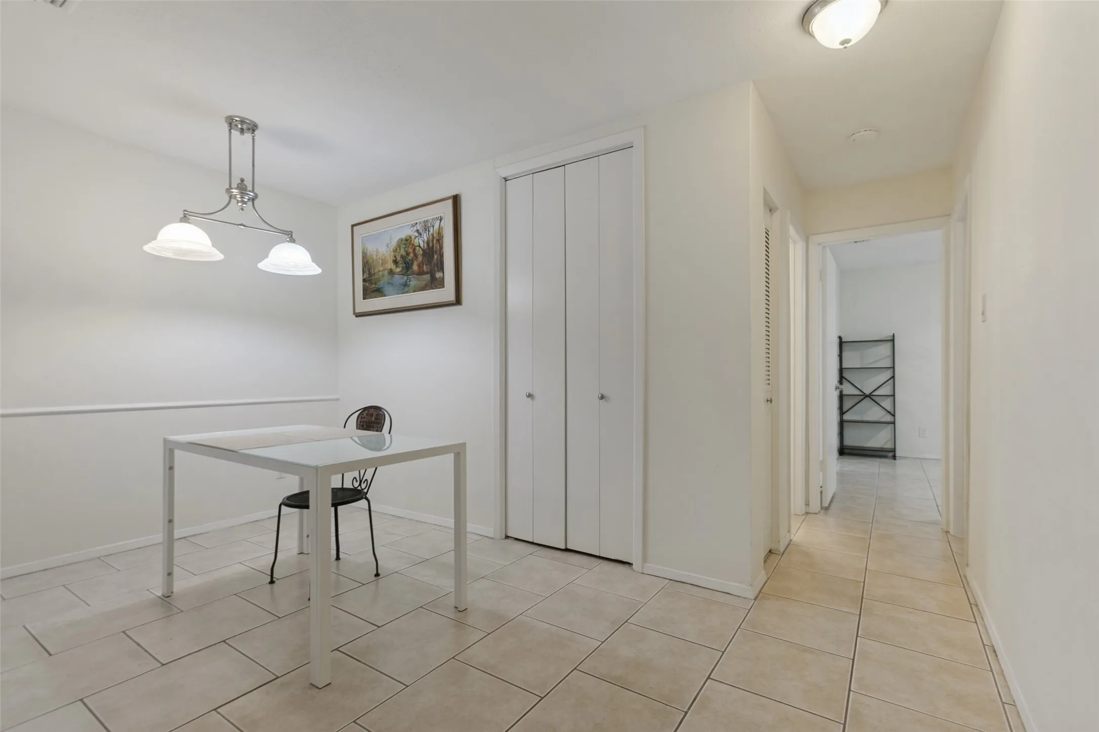 Tiled flooring extends throughout the space and into the hallway