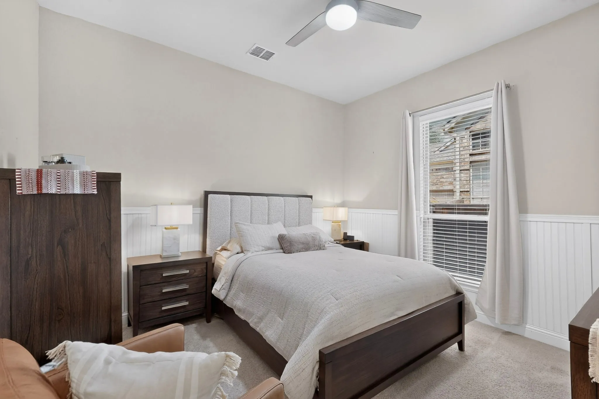 Vaulted ceiling, ceiling fan, carpet flooring, window with blinds, and wainscoting