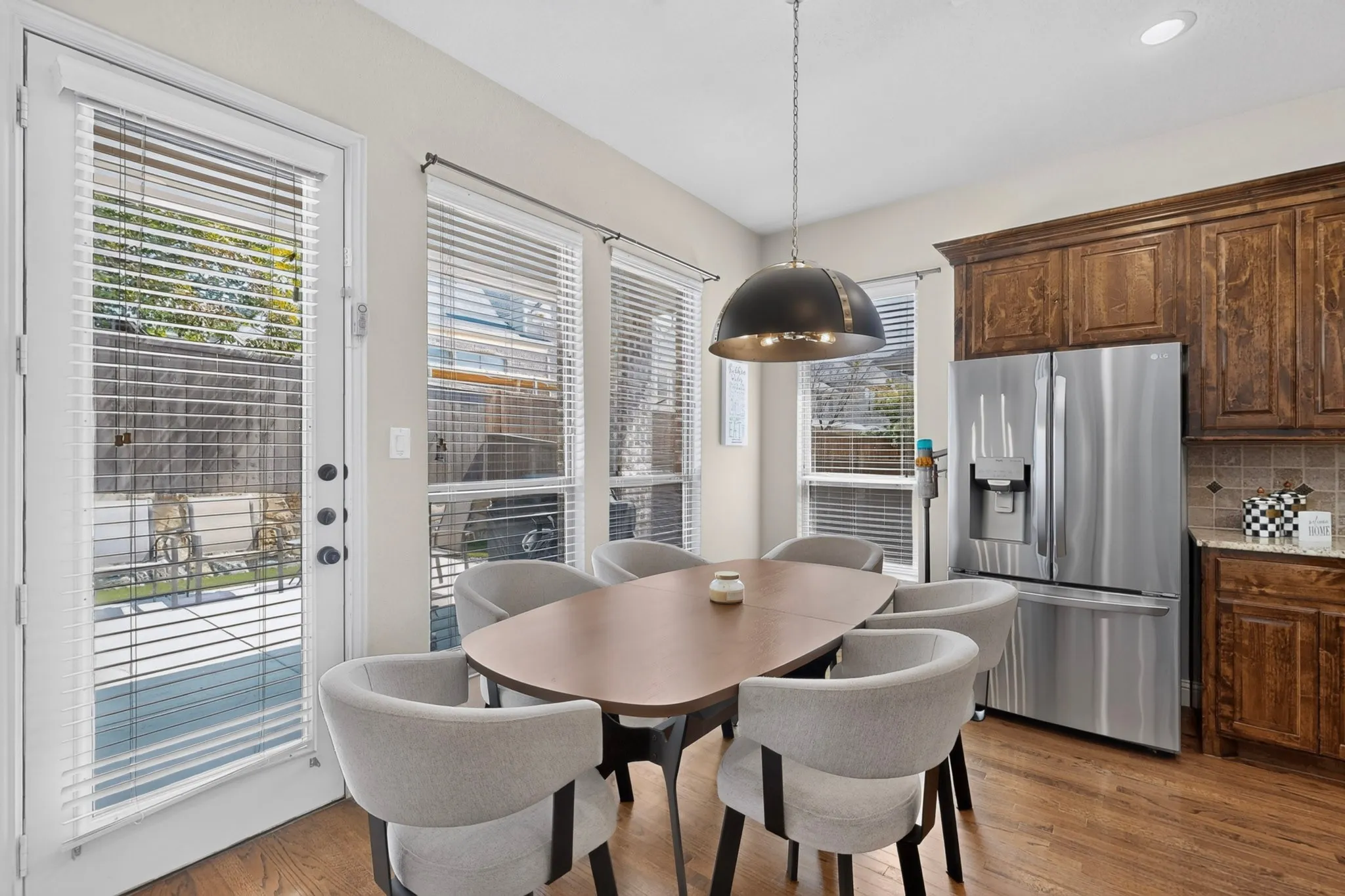Wood-finish flooring, recessed lighting, and a contemporary dome pendant light fixture