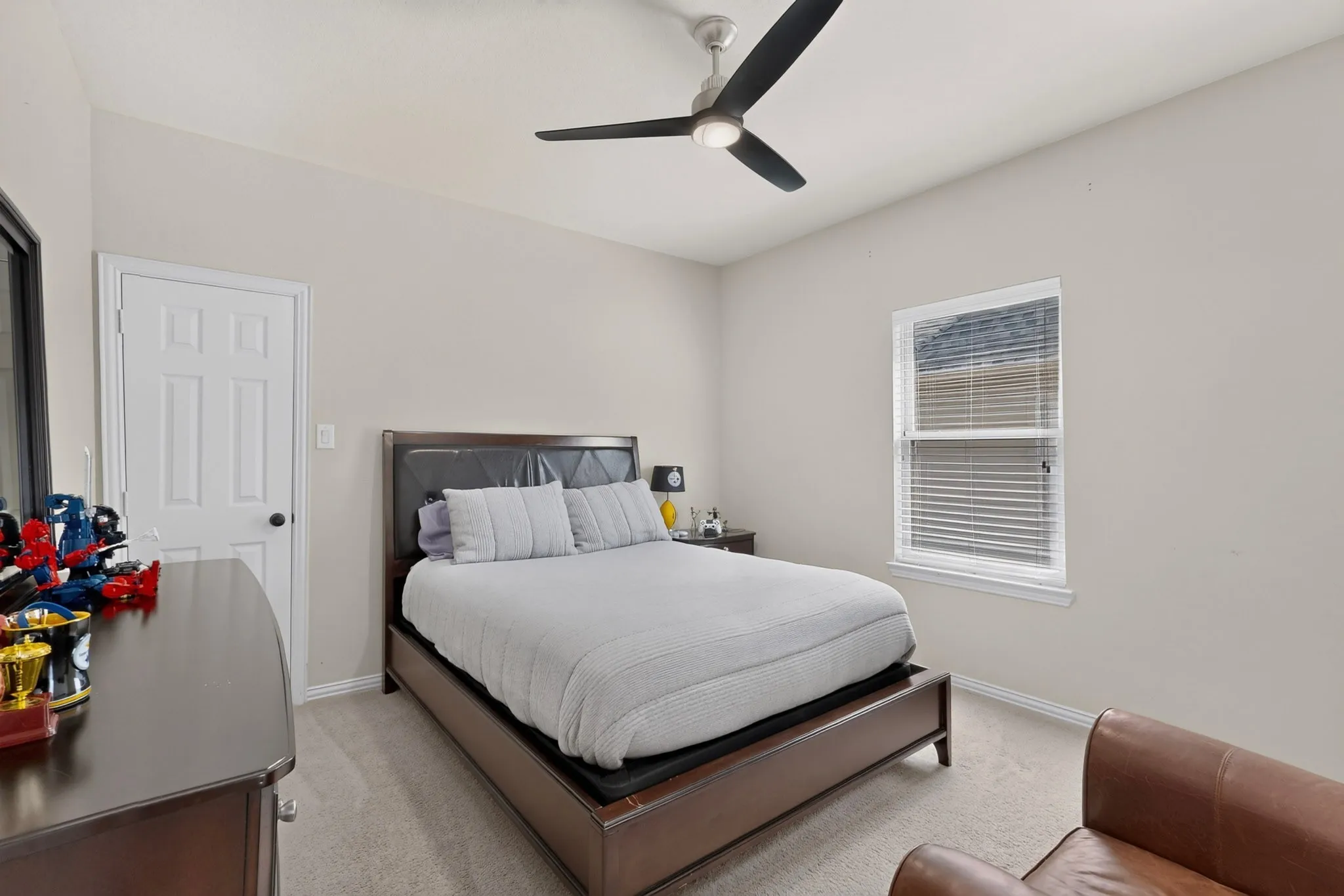 Vaulted ceiling with a contemporary ceiling fan, window with blinds, paneled interior door, and carpet flooring
