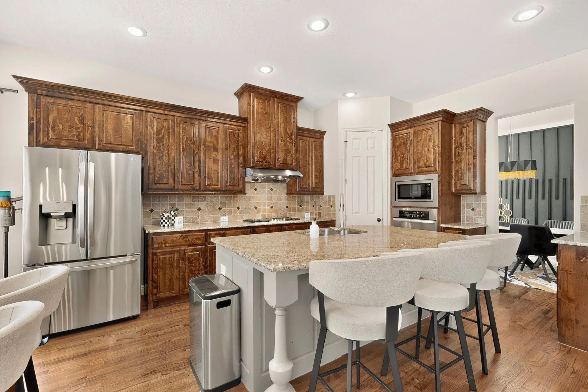 Spacious kitchen featuring wood-finish flooring, recessed lighting, and a kitchen island with stone countertop