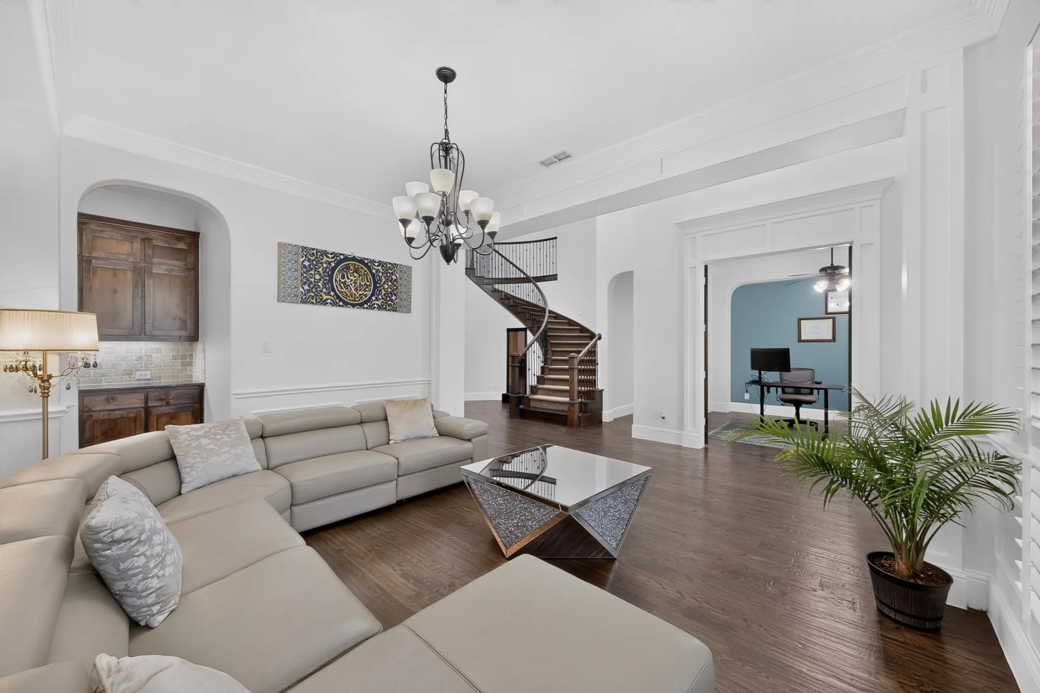 Spacious interior featuring dark wood-finish flooring and a decorative chandelier