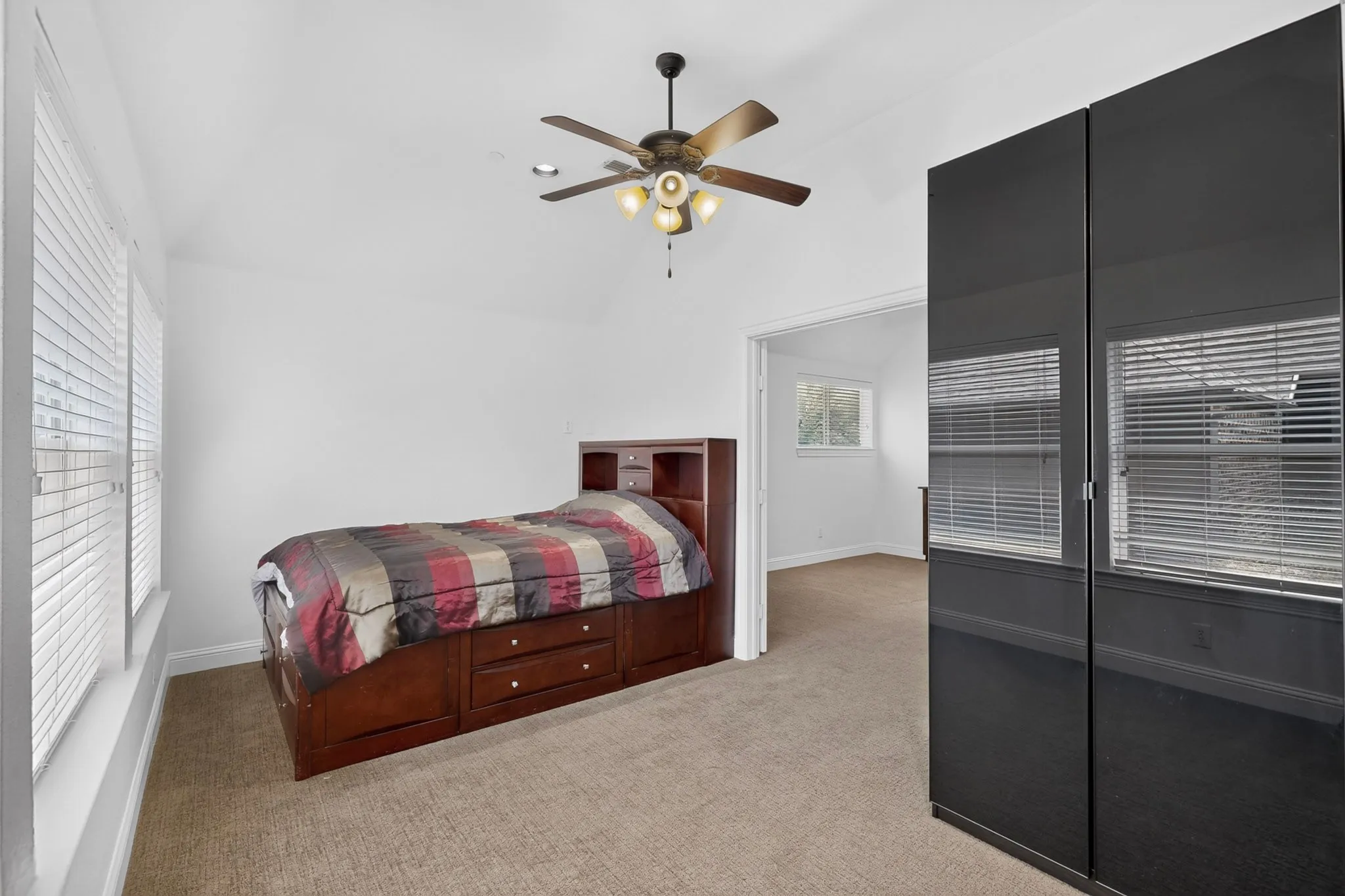 Bright interior room featuring a vaulted ceiling and a ceiling fan with integrated lighting
