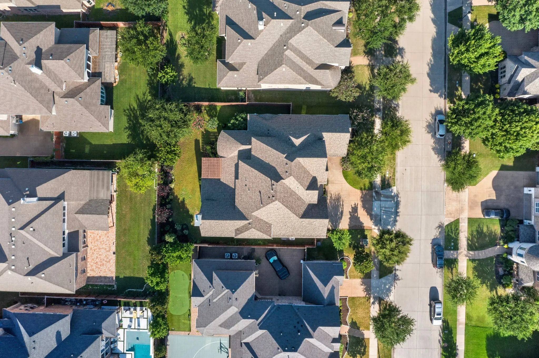Aerial perspective showcasing a residential property with a multi-gabled roof and a paved driveway