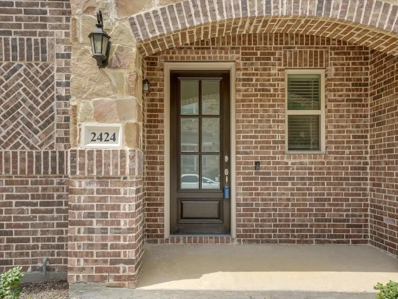 Brick exterior with stone accents and an arched entry