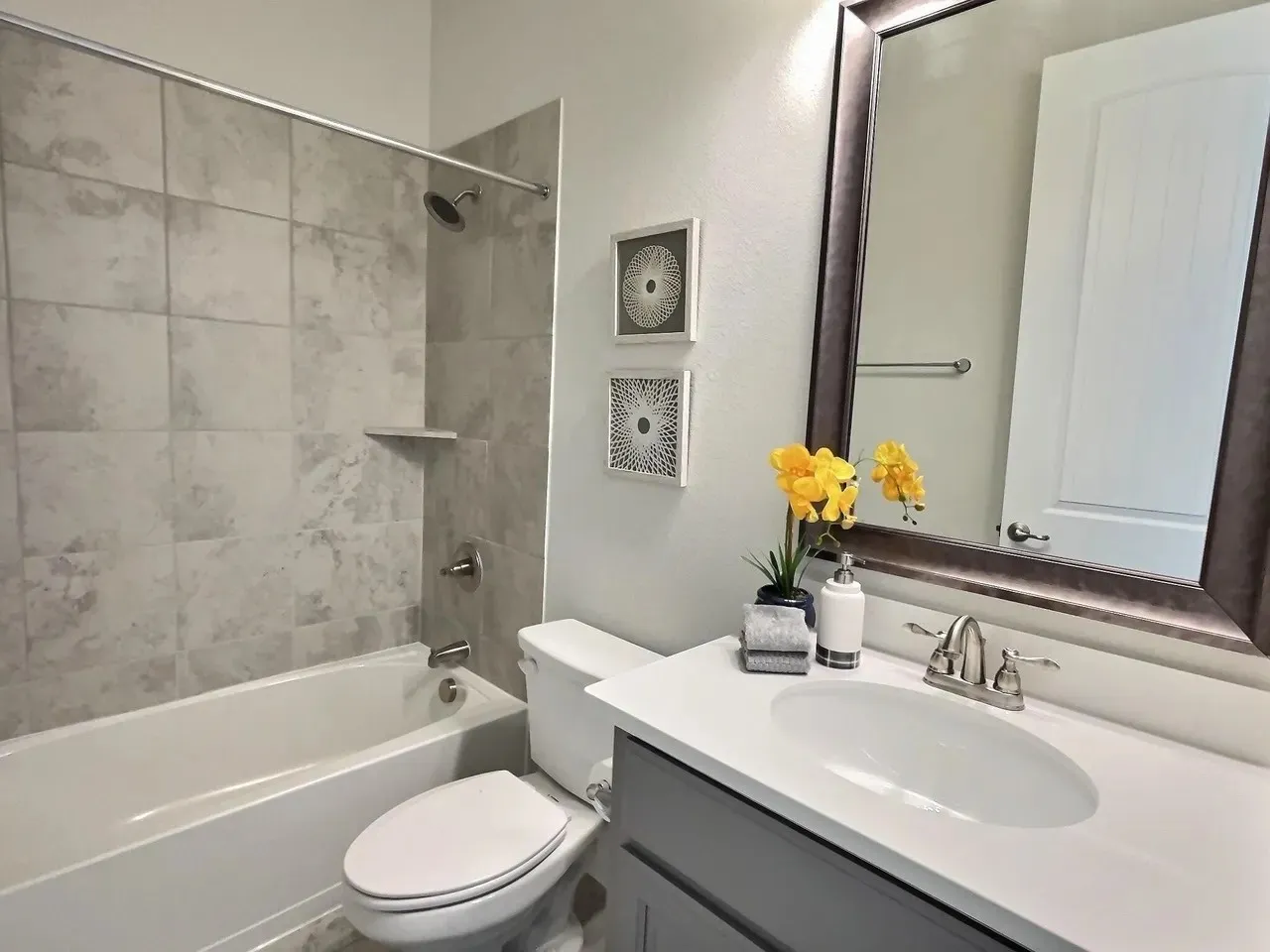 White porcelain bathtub featuring tile surround with built-in shelf