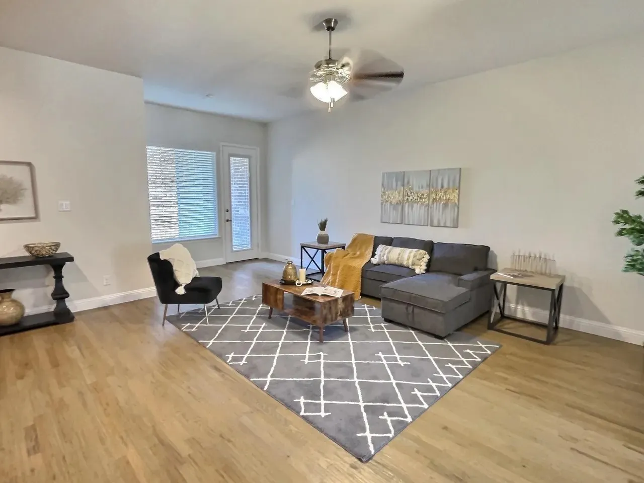 Hardwood flooring throughout, vaulted ceiling, ceiling fan, and white walls
