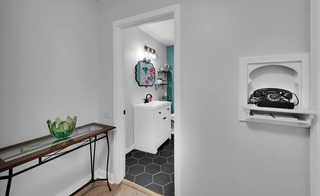 Recessed wall niche, hexagon floor tiling, single vanity, wall-mounted light fixture, white trim