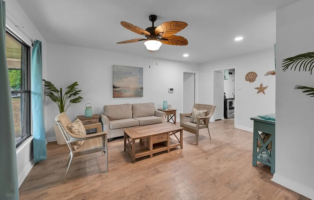 Wood-finish flooring, recessed lighting, and a ceiling fan with leaf-shaped blades