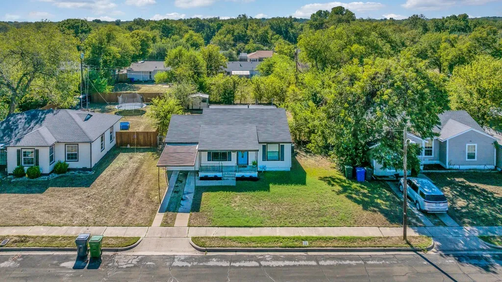 Single-story residence featuring a covered carport, paved driveway, and established front yard
