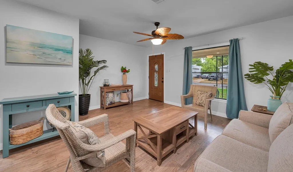Wood-finish flooring, ceiling fan with integrated lighting, and a front entry door with decorative glass inserts