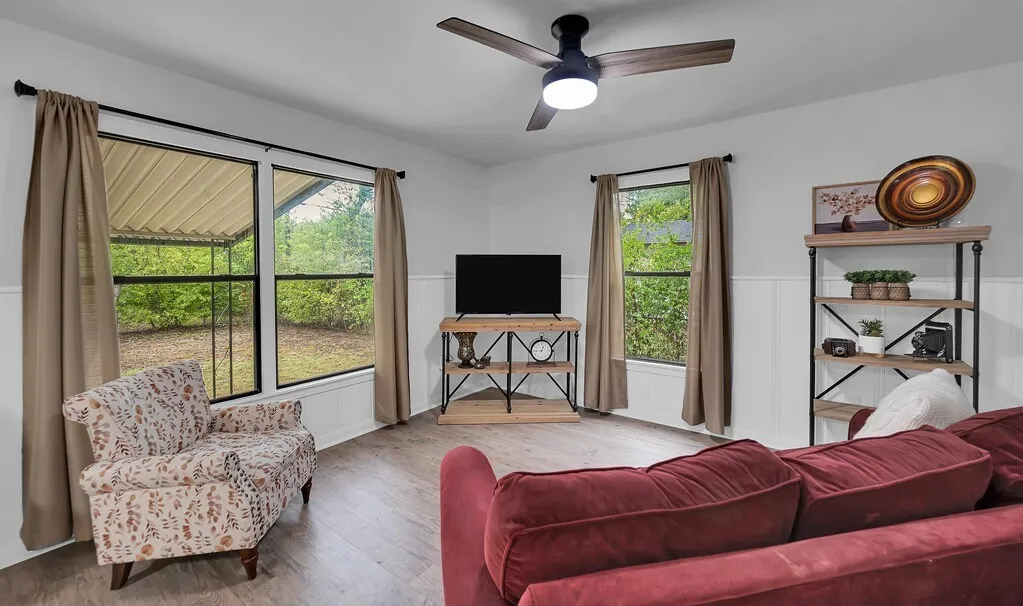 Spacious interior with wood-finish flooring, white walls, and wainscoting