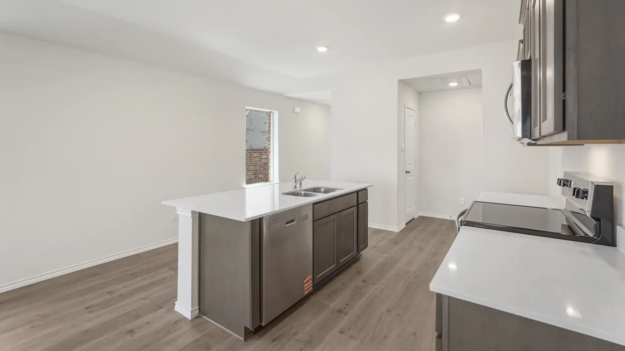 Modern kitchen featuring an island with a double basin sink, stainless steel dishwasher, and white countertops