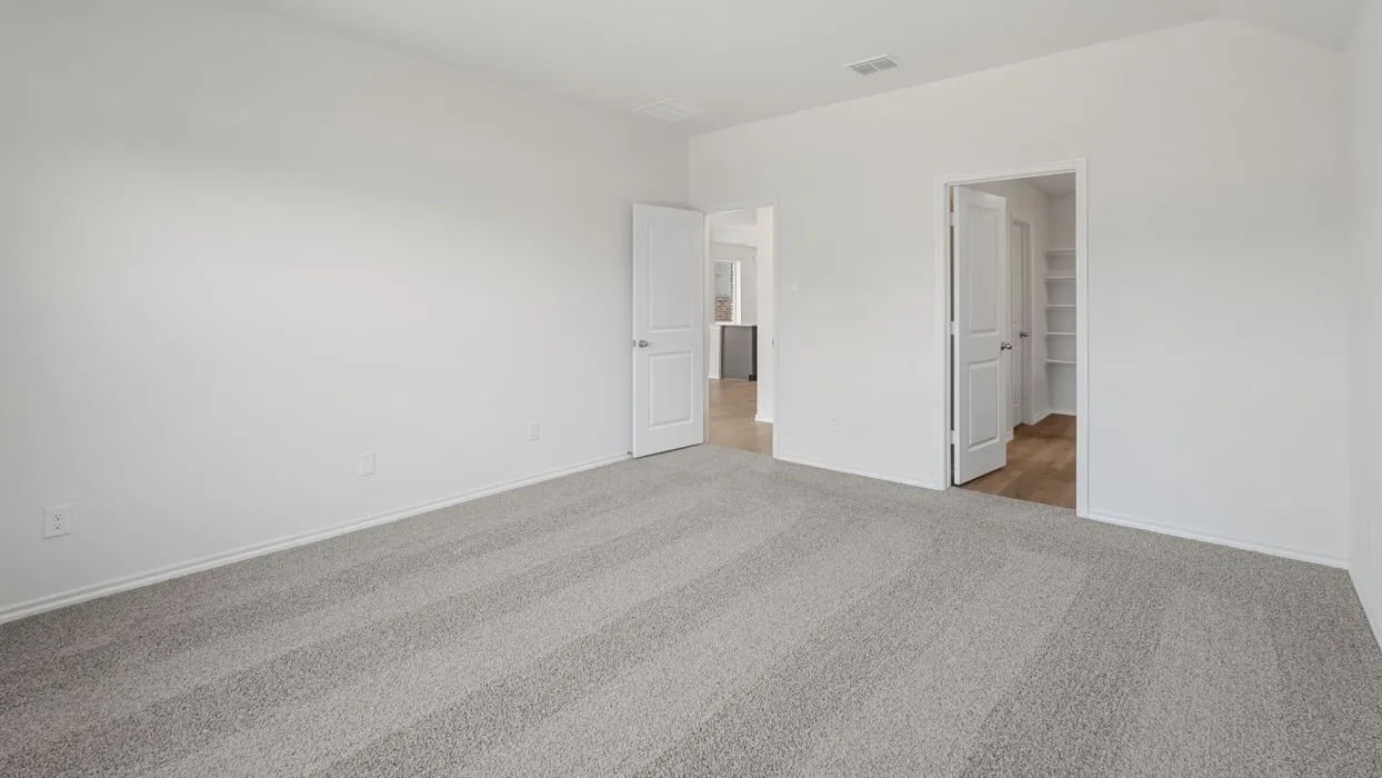 Spacious room featuring light gray carpeting, crisp white walls, and bright white trim