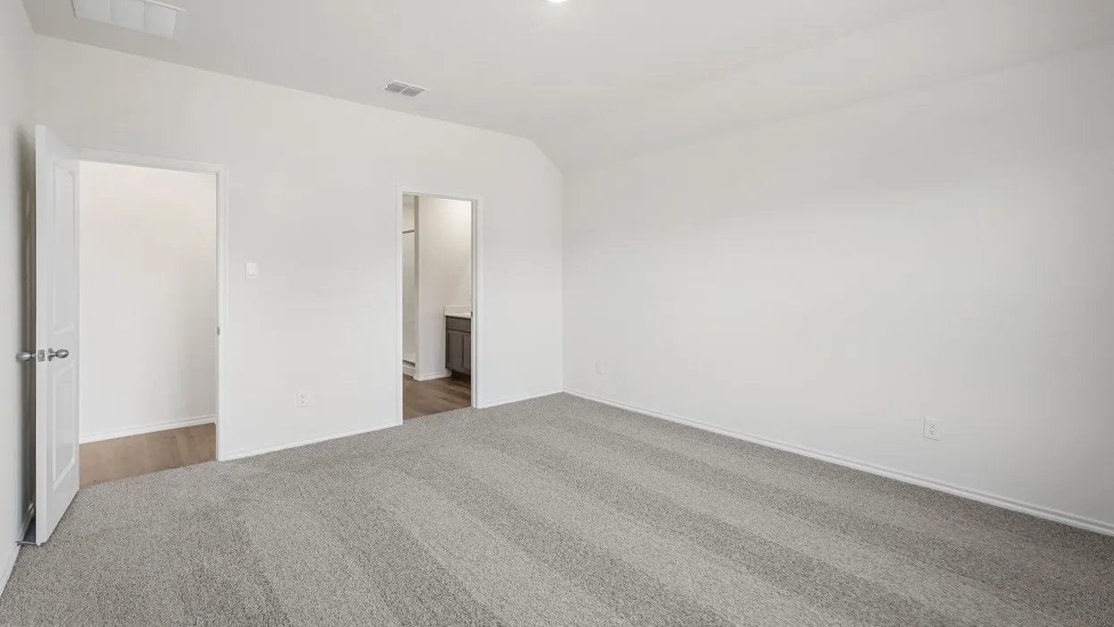 Spacious room featuring light gray patterned carpeting, white walls, two doorways, and a ceiling-mounted light fixture