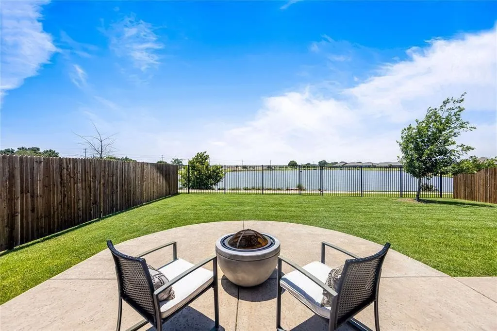 Expansive backyard featuring a manicured lawn, a concrete patio, and a privacy fence