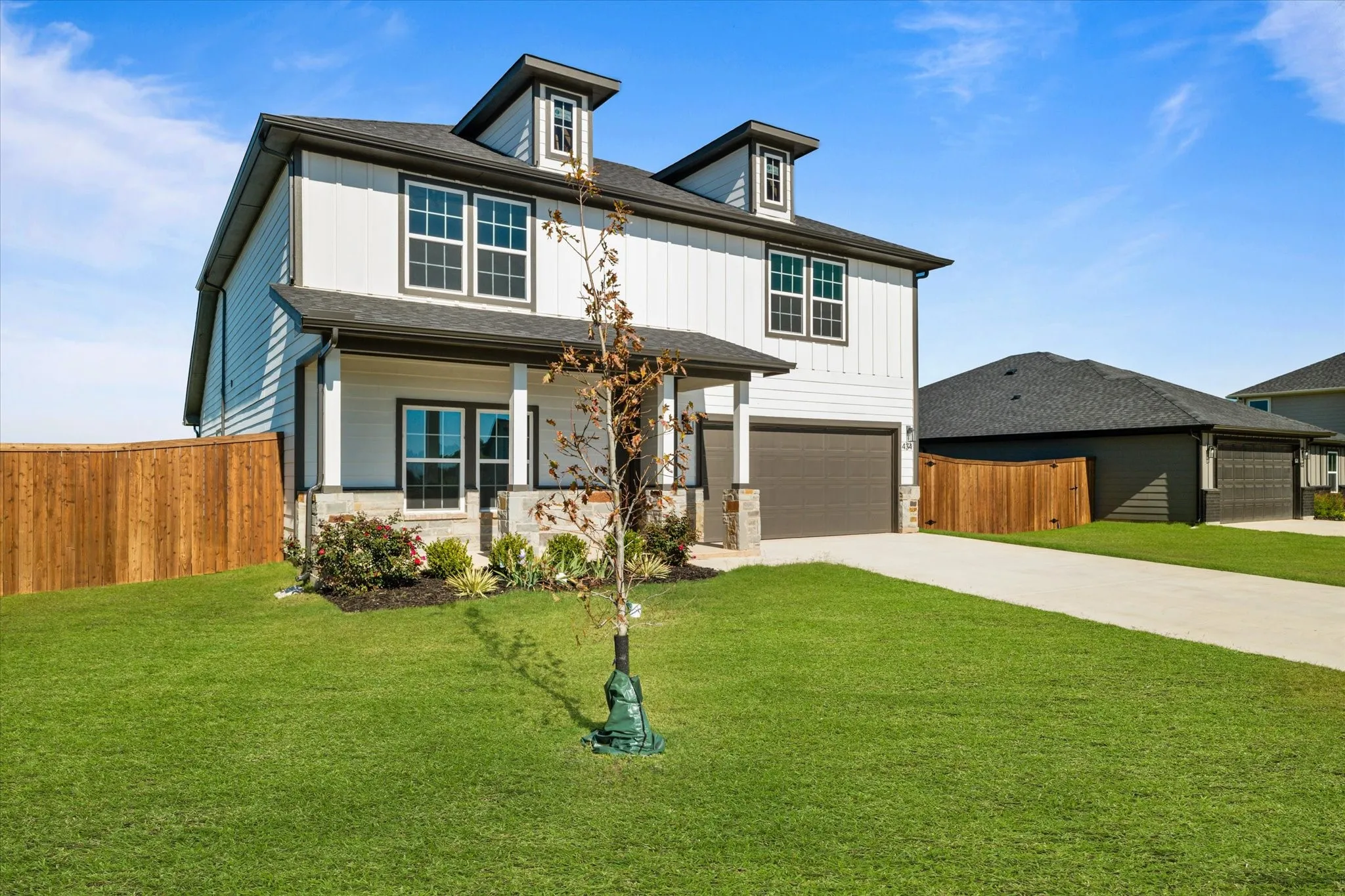 Two-story residence with white vertical siding and dark trim