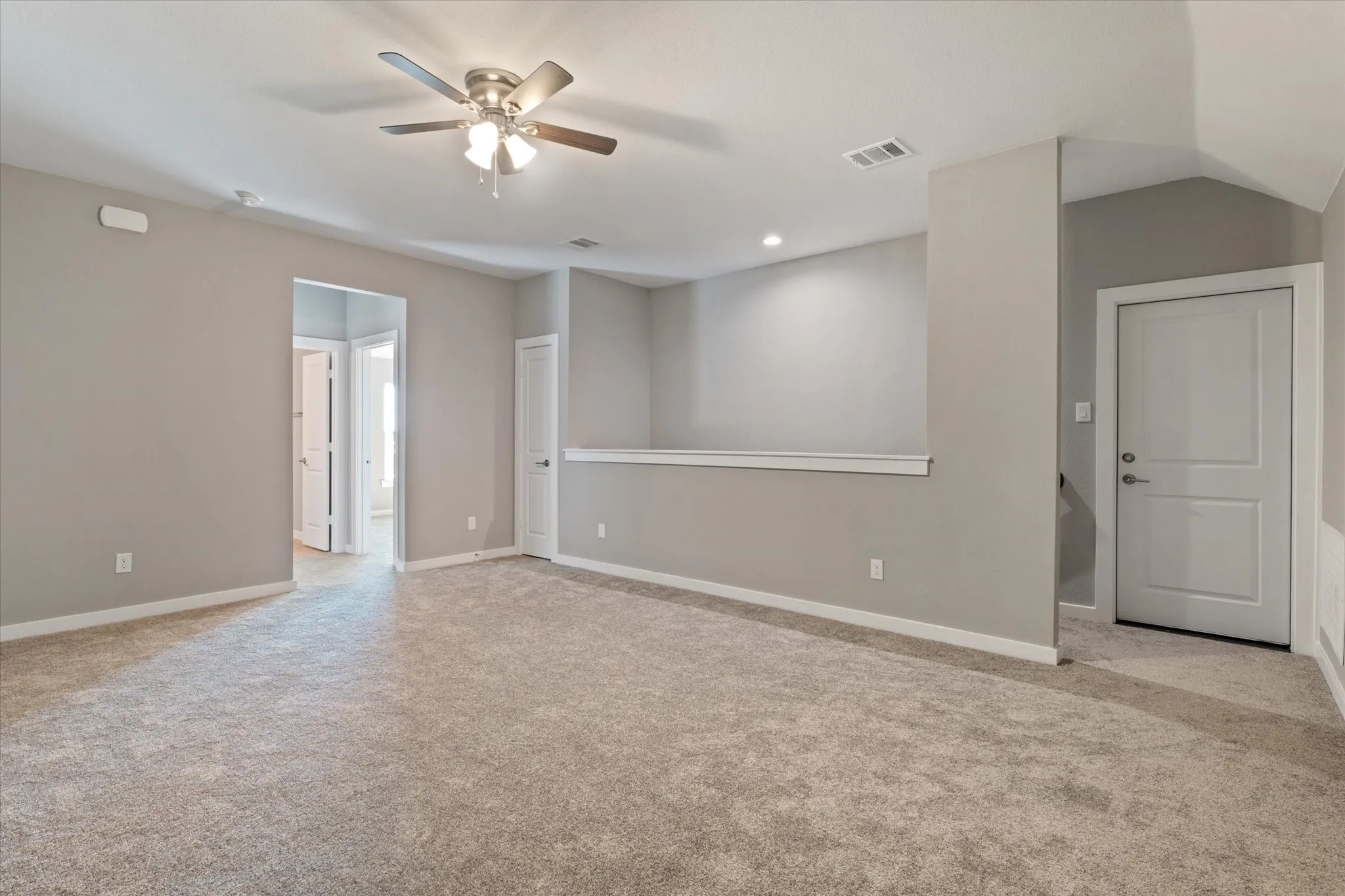 Expansive carpeted area with a ceiling fan, recessed lighting, and light gray walls