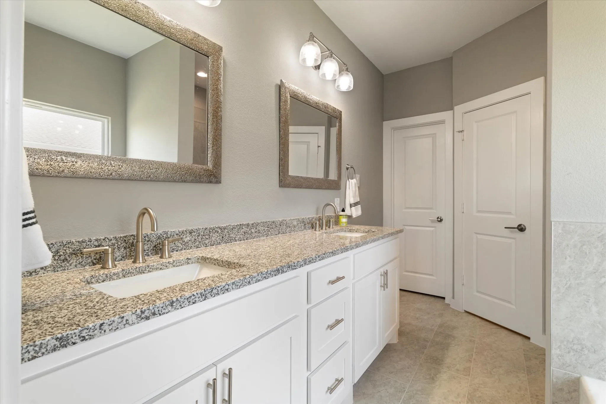 Dual vanity with granite countertop, undermount sinks, and brushed nickel fixtures