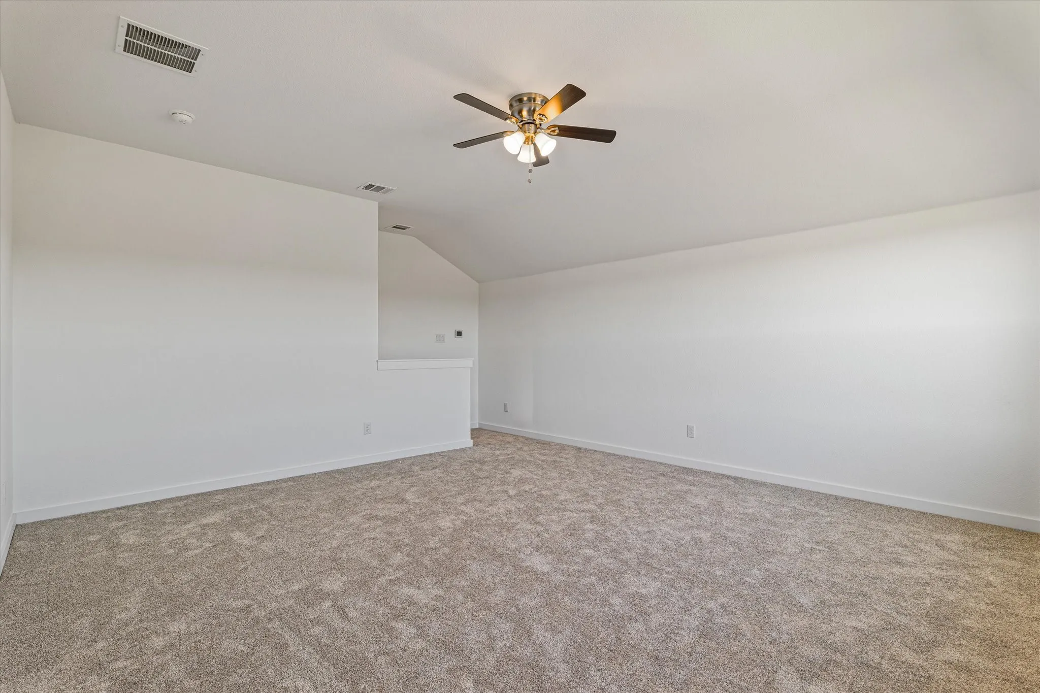 Vaulted ceiling with a ceiling fan, neutral carpet flooring, and white painted walls