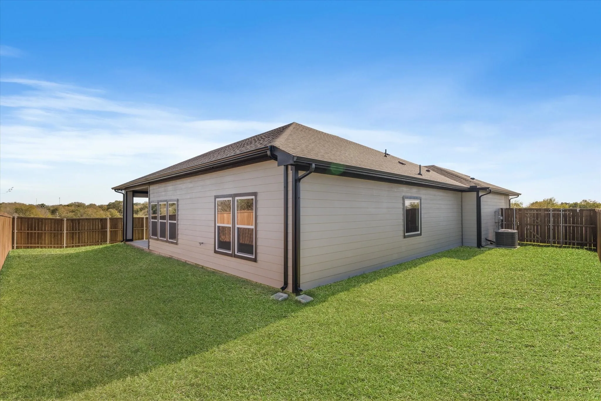 Spacious grassy yard with wood fencing