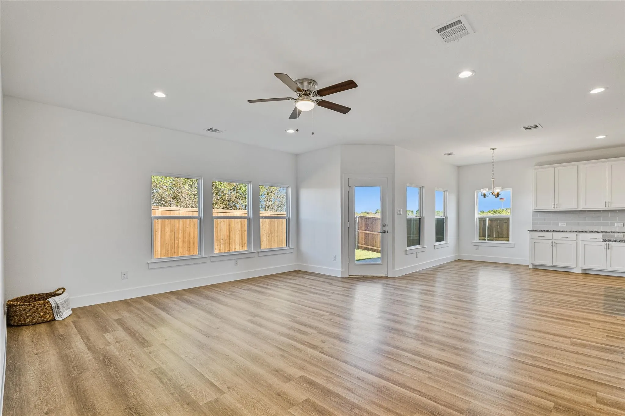 Open-concept common area featuring wood-finish flooring, white walls, and recessed lighting