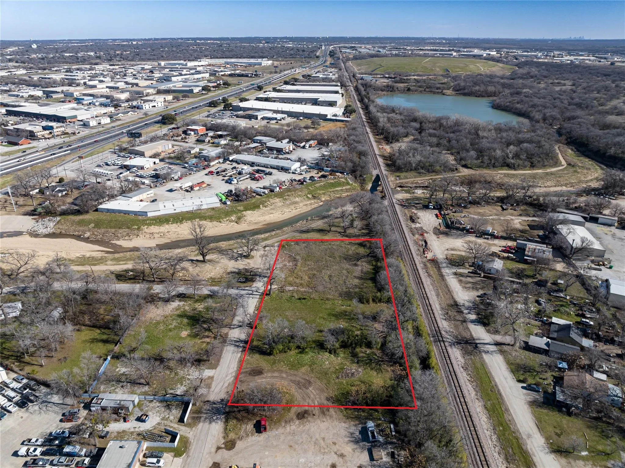 Aerial overview of property's location with property boundaries highlighted and a nearby body of water