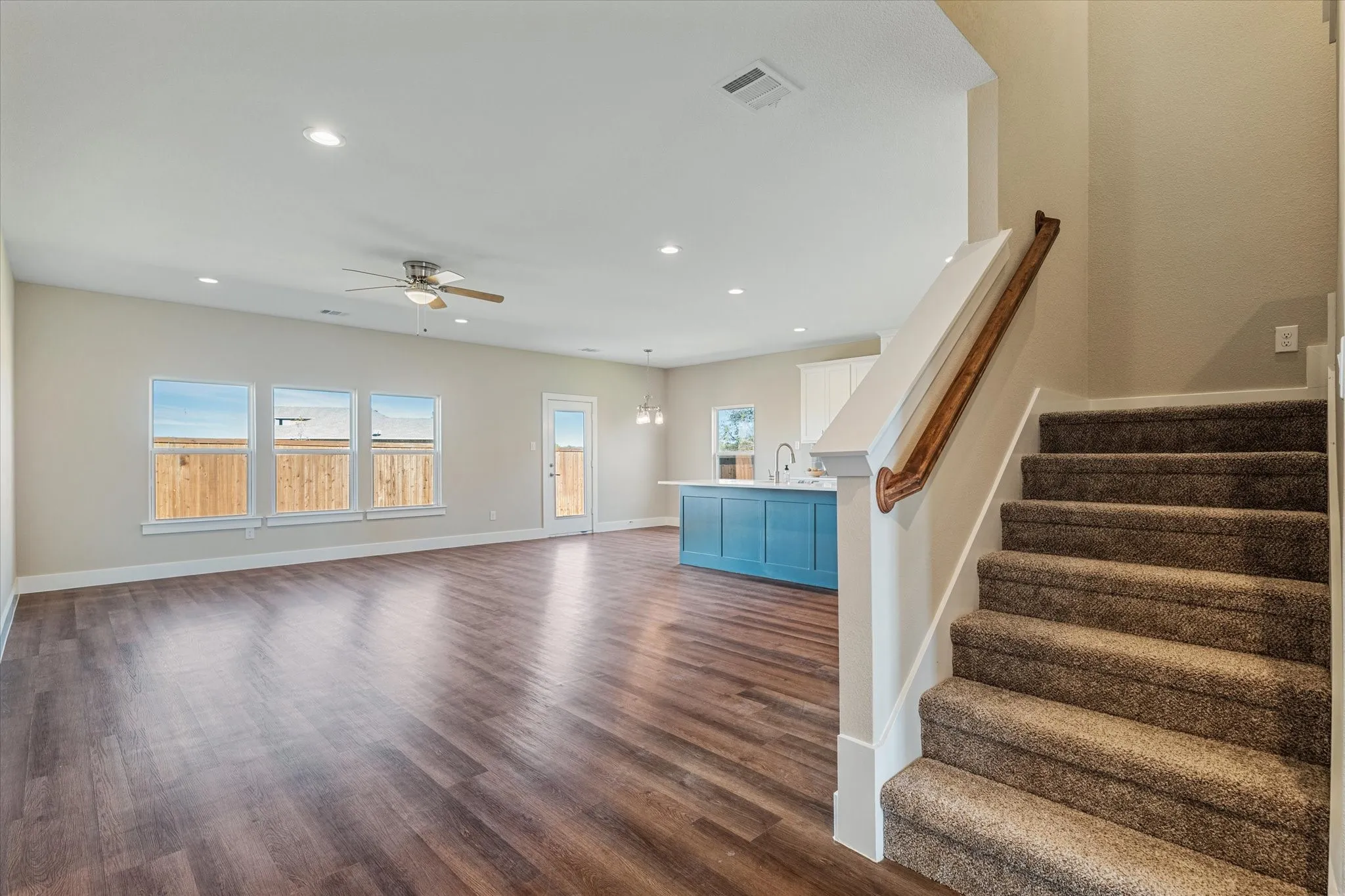 Spacious living area featuring wood-finish flooring, recessed lighting, and a ceiling fan