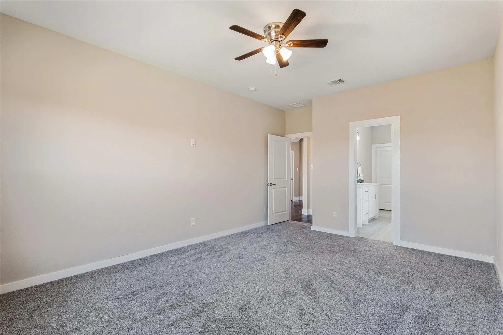 Neutral paint, ceiling fan, and grey carpet flooring