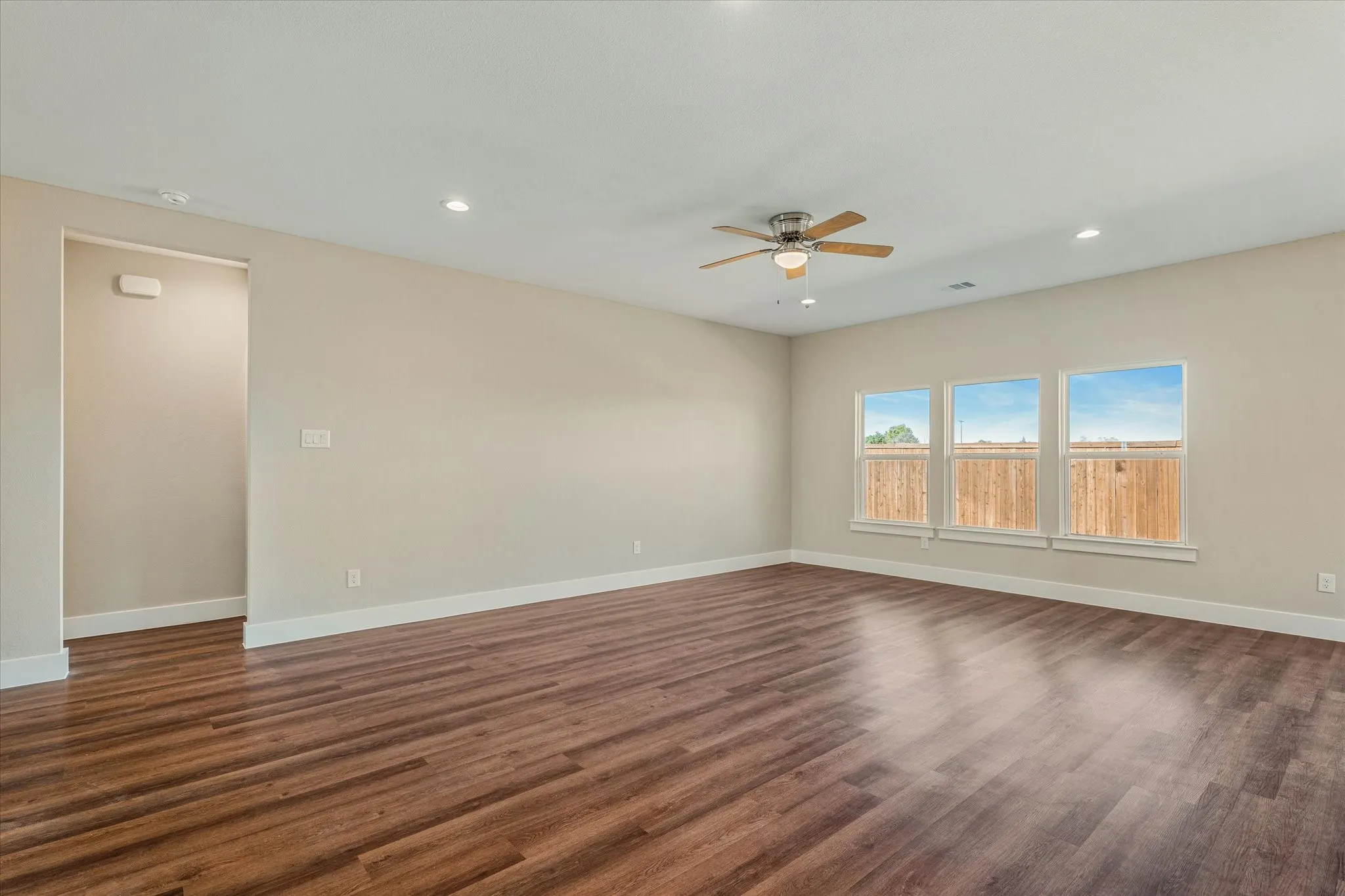 Wood-finish flooring, recessed lighting, and a ceiling fan with light fixture