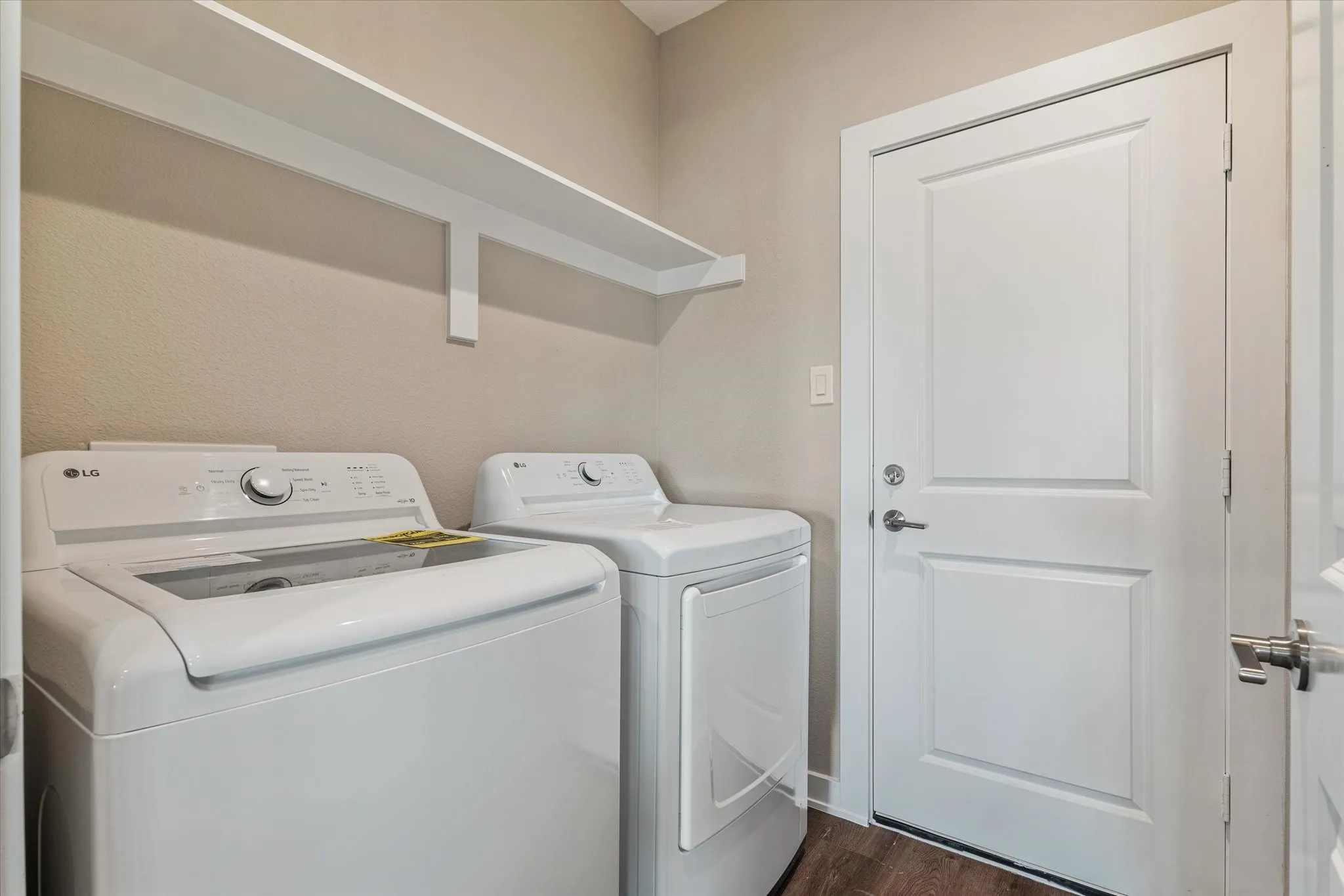 Laundry area with built-in shelving and wood-finish flooring