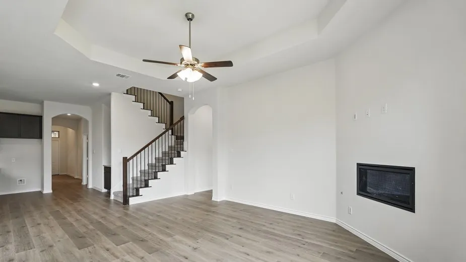 Spacious living area featuring wood-finish flooring, a recessed ceiling, and an integrated fireplace