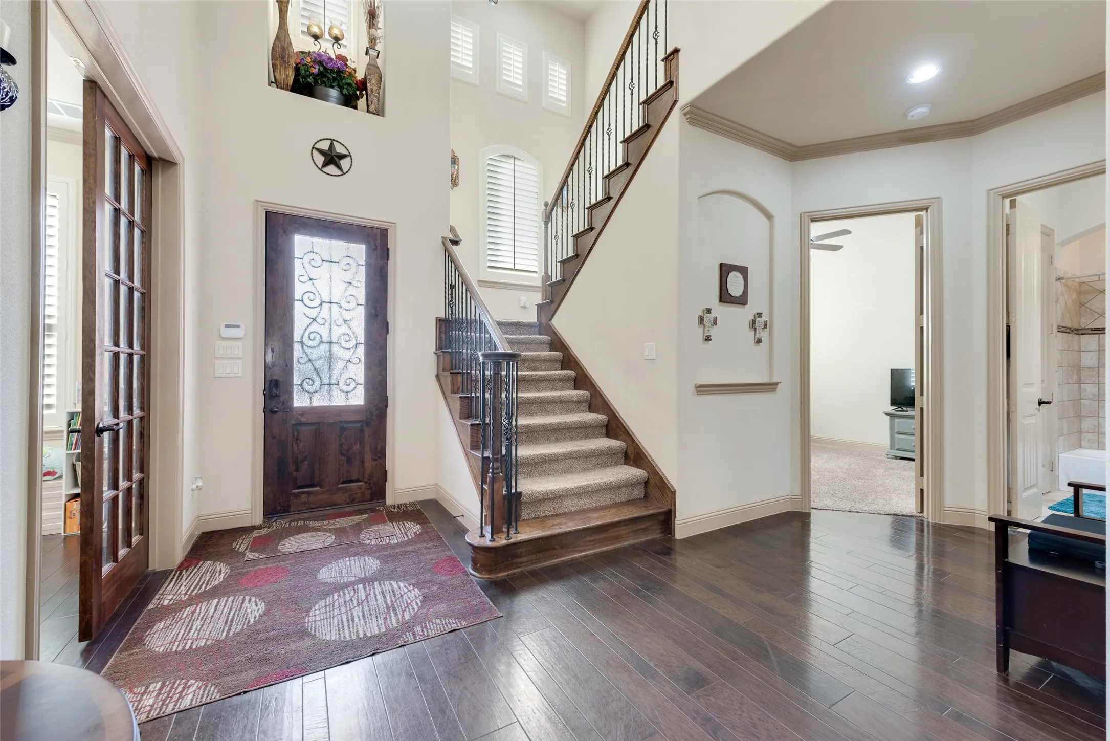 Inviting Foyer with ornamental molding, dark wood-type flooring, and a wealth of natural light