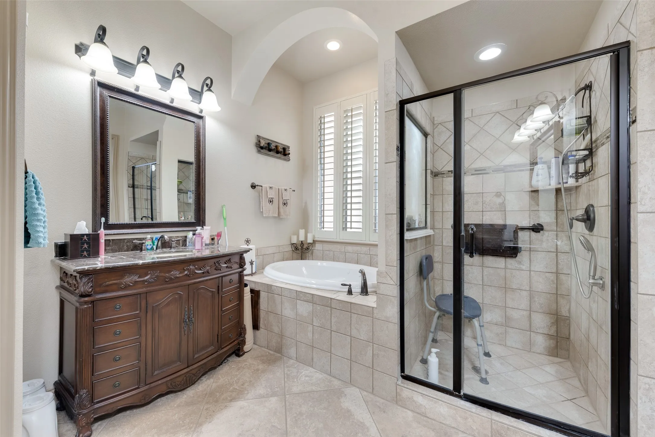 Downstairs Primary Bathroom #1 with separate vanities, tile patterned flooring, and separate shower and bath